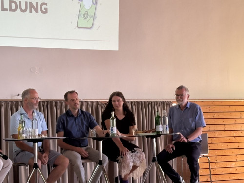 Menschen bei Podiumsdiskussion